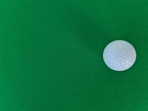 Premium Photo | White golf ball on green grass cloth