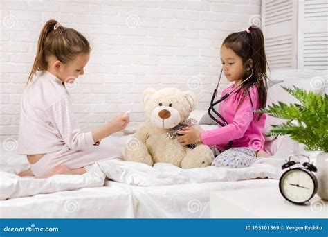 Two Cute Children Girls Playing Doctor With Teddy Bear At Home Obraz