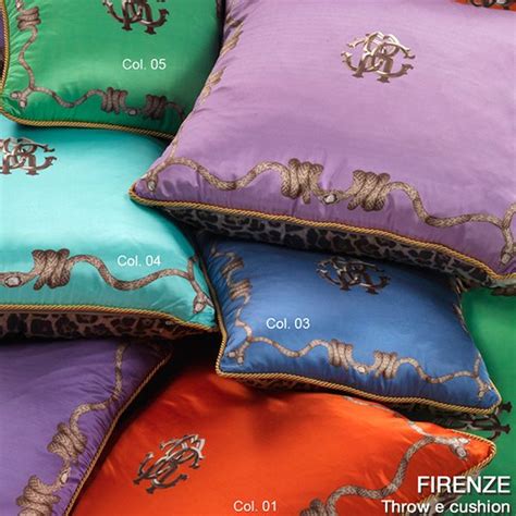 Four Different Colored Pillows Stacked On Top Of Each Other With Gold