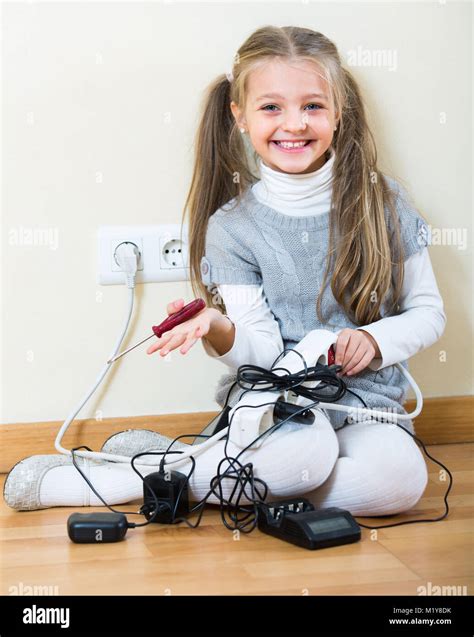 Cheerful Little Girl Dangerously Playing With Sockets And Electricity