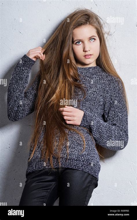 Fashion Teenager Girl Standing Leaning Back Against A White Concrete