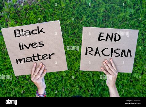 Hands Of Young People Holding Cardboard Signs With Slogans Against