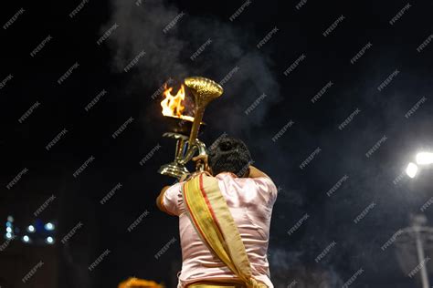 Premium Photo | Ganga aarti Portrait of young priest performing holy ...