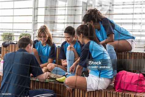Female Soccer Players Paying Attention To Their Male Coah Who Is