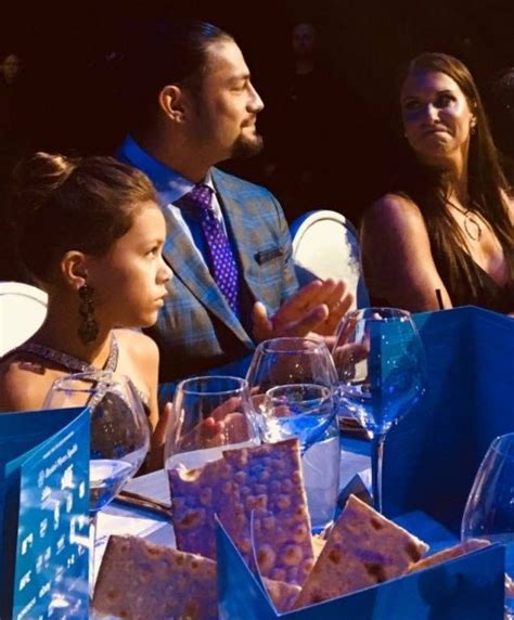 A Man And Two Women Sitting At A Table With Wine Glasses In Front Of Them