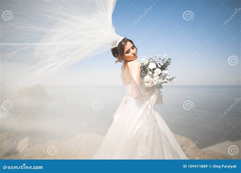 Lovely Bride In White Wedding Dress Posing Near The Sea With Beautiful