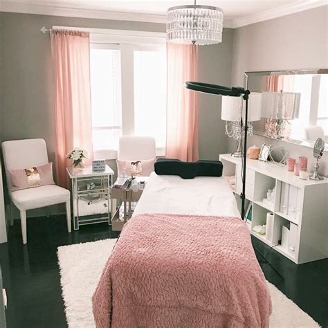 A Bedroom Decorated In Pink And White With A Chandelier Hanging From