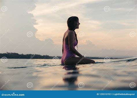 Happy Female Surfer Sitting On Surfboard In Water Stock Photo Image