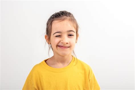 Une Petite Fille Caucasienne Fait Des Grimaces Sur Un Fond Blanc Isol