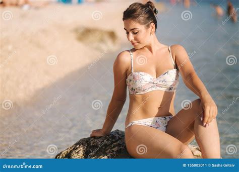 Beautiful Woman In Bikini Sit On The Stone In Front Of Sea Stock Image