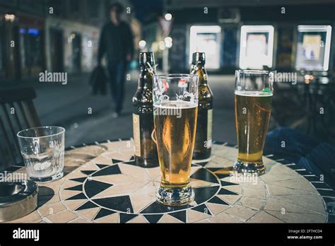 Two Lager Beers In Half Litre Glasses On A Bar Table Outdoor During Evening Hours With Brown