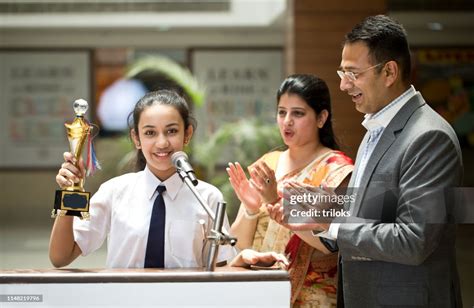 Teachers Applauding For Student At Awards Ceremony High Res Stock Photo