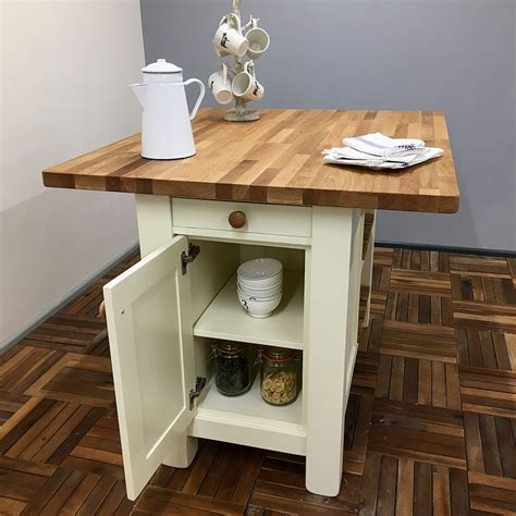 A Small Kitchen Island With An Open Door On The Side And Shelves