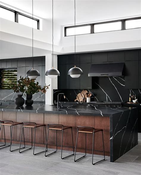 A Modern Kitchen With Marble Counter Tops And Bar Stools In The Center