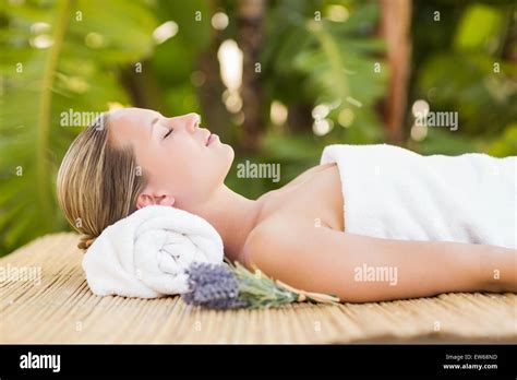 Peaceful Blonde Lying On Bamboo Mat With Flowers Stock Photo Alamy