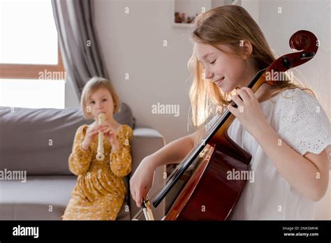 Happy Girls Playing Musical Instruments At Home Stock Photo Alamy