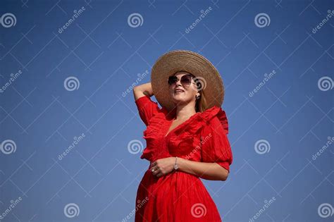 A Woman In A Red Dress And Straw Hat Is Smiling And Looking Up At The Sky Stock Image Image Of