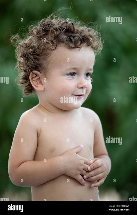 Beautiful Baby With Curly Hair In The Garden Without T Shirt Stock