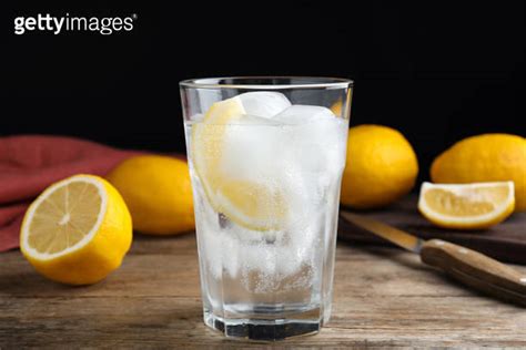 Soda Water With Lemon Slices And Ice Cubes On Wooden Table