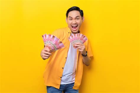 Premium Photo Excited Young Handsome Asian Man Holding Bunch Of Money