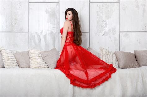 Mulher Jovem Sexy Vestido Transparente De Lingerie Vermelha E Lingerie Ao Lado Da Cama Cremosa
