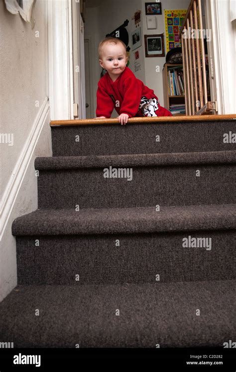 A Baby Boy Holding On To The Baby Safety Gate And Then Crawling Down