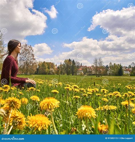 Beautiful Young Woman Relaxing On A Meadow With Many Dandelions On A