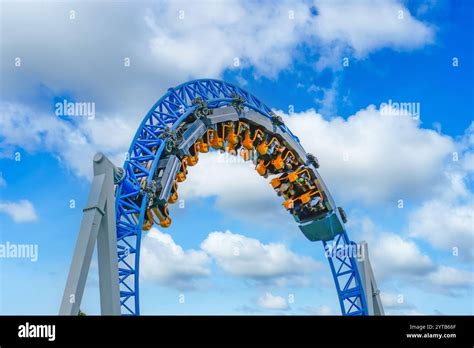 Roller Coaster Cart With People Riding It Goes Through A Loop Upside