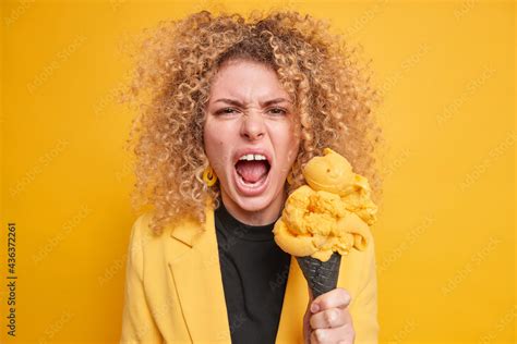 Outraged Curly Haired Woman Screams Angrily Keeps Mouth Opened Holds