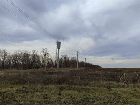 Agricultural Field Electric Poles And Water Tower In Winter Stock Photo