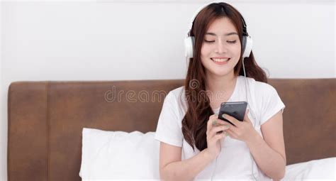 Beautiful Asian Women Wearing Headphones Listening To Music Streaming