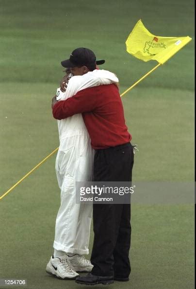 Tiger Woods of the USA embraces his caddie Mike "Fluff" Cowan on the ...