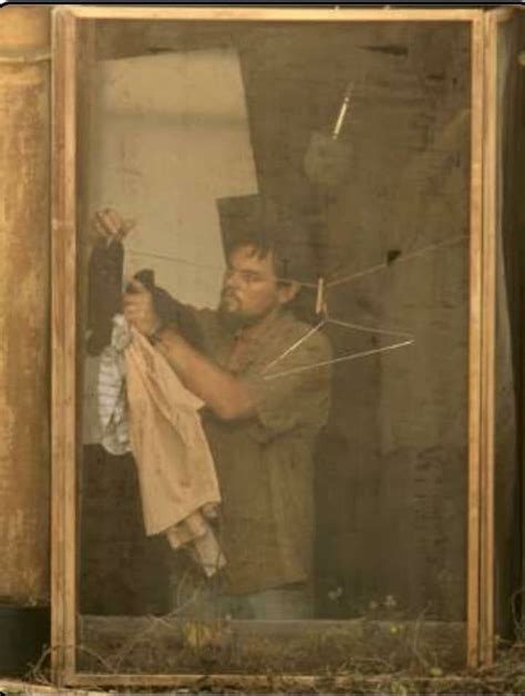 A Man Holding An Umbrella While Standing In Front Of A Window