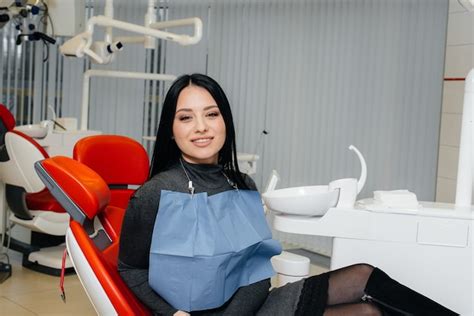 Uma paciente de uma clínica odontológica está sentada em uma cadeira e