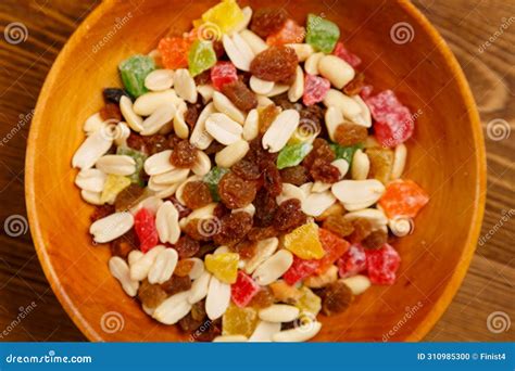 Scattered Mix Of Dried Fruits And Nuts On A Wooden Plate Stock Photo