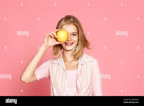 Blonde Woman Covers One Eye With Fresh Apple Stock Photo Alamy