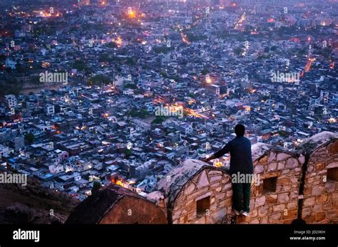 Man looking over the fort walls of Nahargarh to see the lights of ...