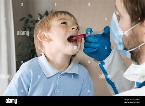 Niño recibiendo gotas de polio Médico que hace a los niños Vacunación