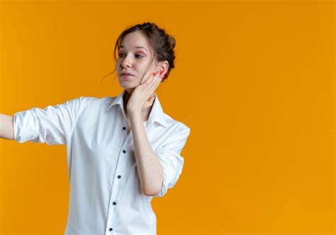 Jeune Fille Russe Blonde Heureuse Met La Main Sur Le Visage à Côté Isolé Photo Gratuite