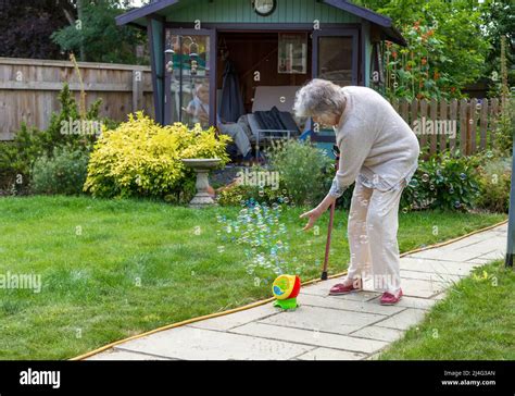 Grandmother Having Fun With Bubbles In Garden Proving Youre Never Too