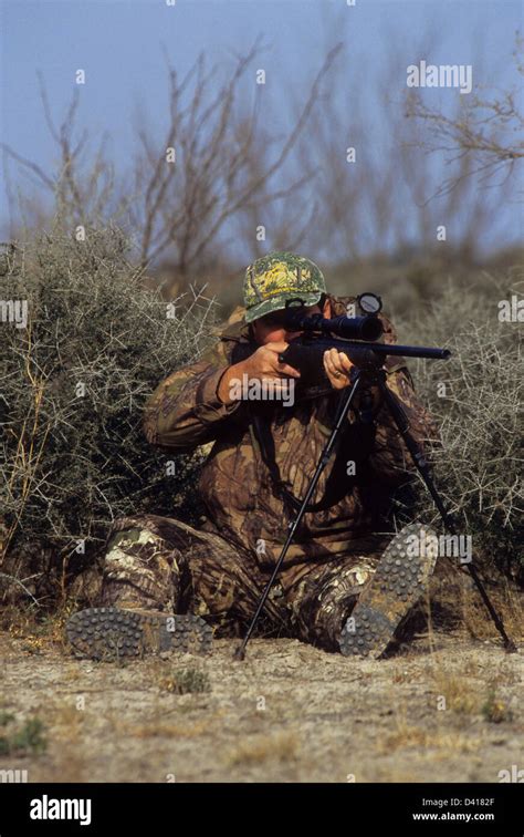 A South Texas Deer Hunter Looking Through His Scope And Aiming A Rifle