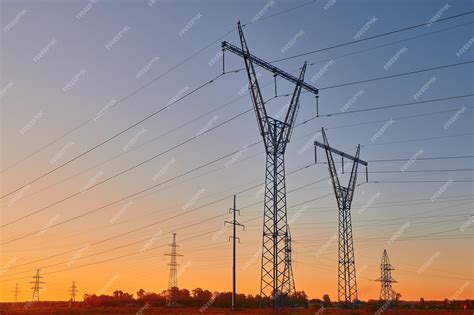 Siluetas Oscuras De Líneas Eléctricas En El Amanecer Ardiente Torres De Electricidad De Alto