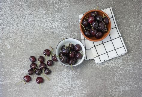 Premium Photo Two Bowls With Cherries On The Table