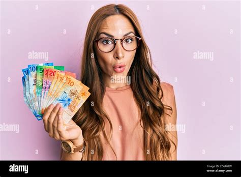 La jeune femme brunette qui détient des billets de banque en franc suisse a peur et a été