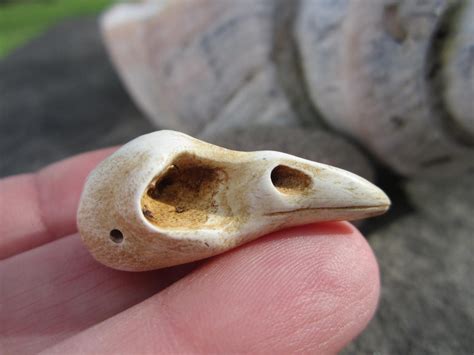 A Small Bird Shaped Object Sitting On Top Of A Persons Finger