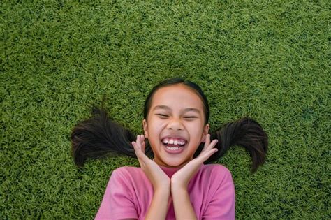 Premium Photo Happy Girl Lying On Grass
