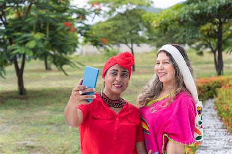 Duas mulheres multiétnicas tirando uma selfie em um parque Foto Premium