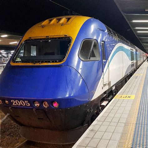 a blue and yellow train is stopped at the station with people waiting ...