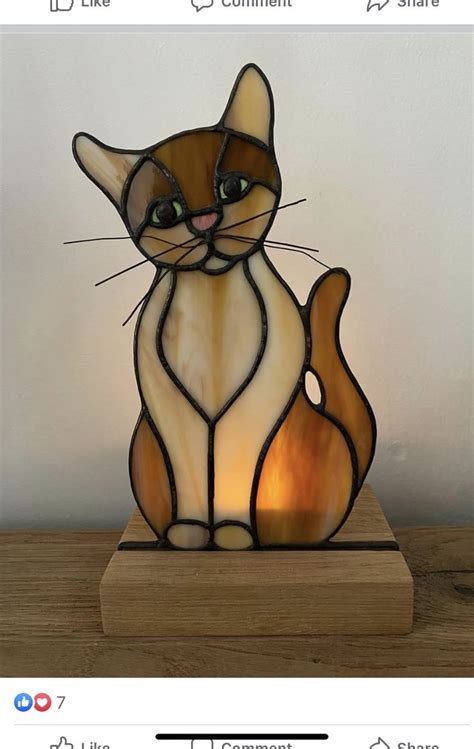 A Stained Glass Cat Sitting On Top Of A Wooden Table