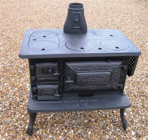 An Old Fashioned Stove Sitting On Top Of Gravel